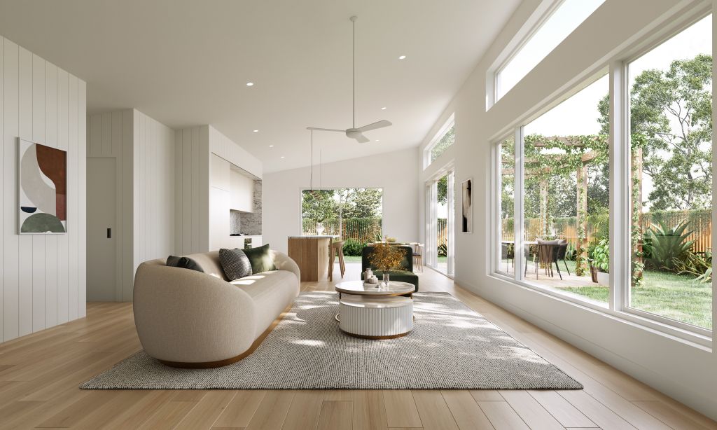 Bright living room with curved beige sofa, round coffee table, ceiling fan and floor-to-ceiling windows opening to outdoor entertaining area